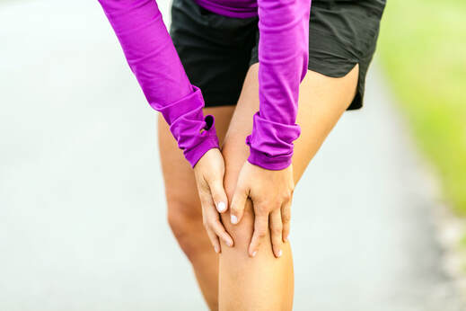 Woman cradling leg due to knee pain from running